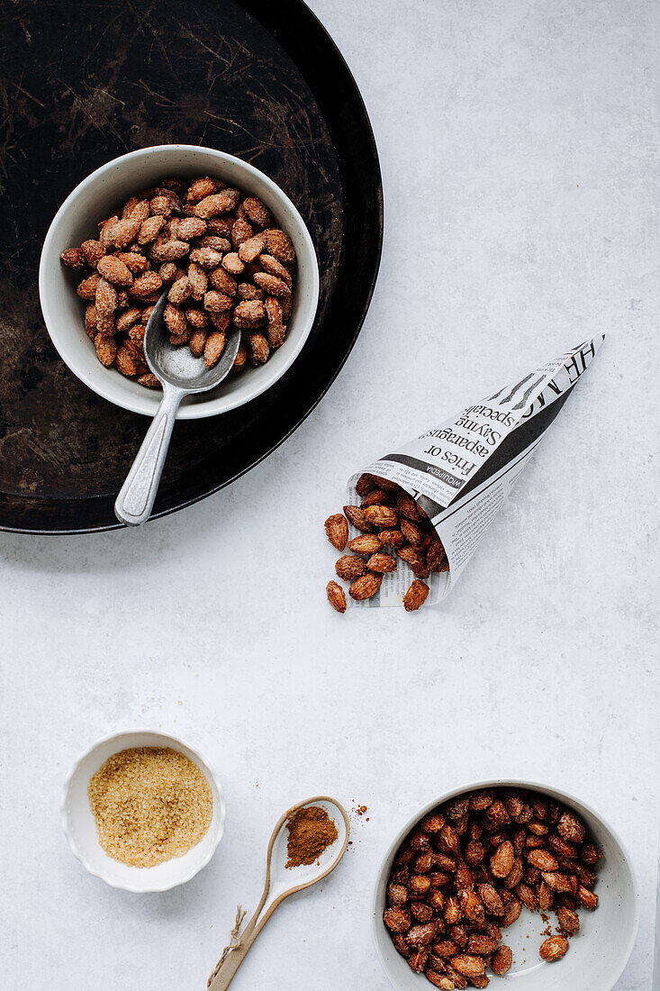 Roasted almonds in bowls and a paper bag