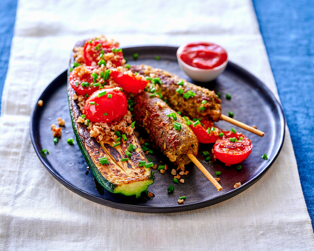 Minced meat skewers and fried zucchini with tomatoes