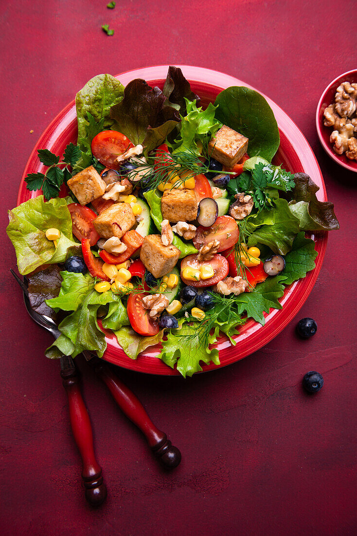 Salad with bell pepper, corn, walnuts, blueberries, and tofu