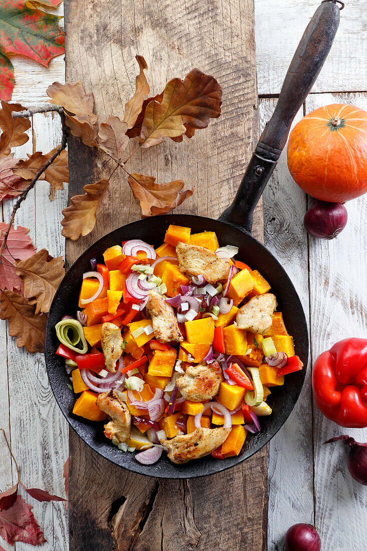 Herbstliche Gemüsepfanne mit Hühnchen, Kürbis, Paprika und roten Zwiebeln