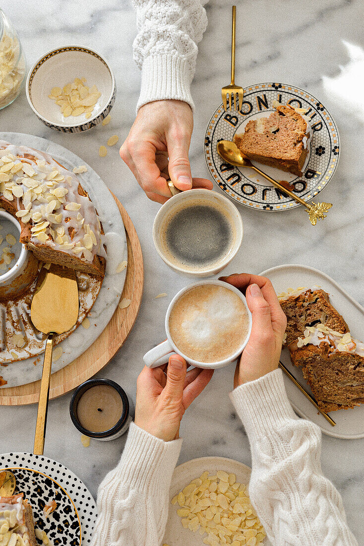 Hände mit Kaffeetassen und Apfelkuchen