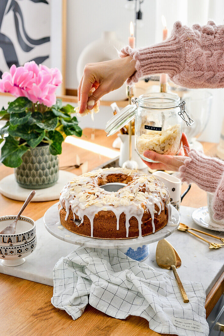 Glasierten Apfelkuchen mit Mandelblättchen bestreuen