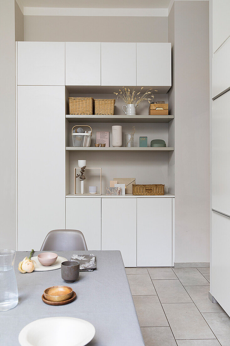 View over dining table to cupboard with shelves in open module