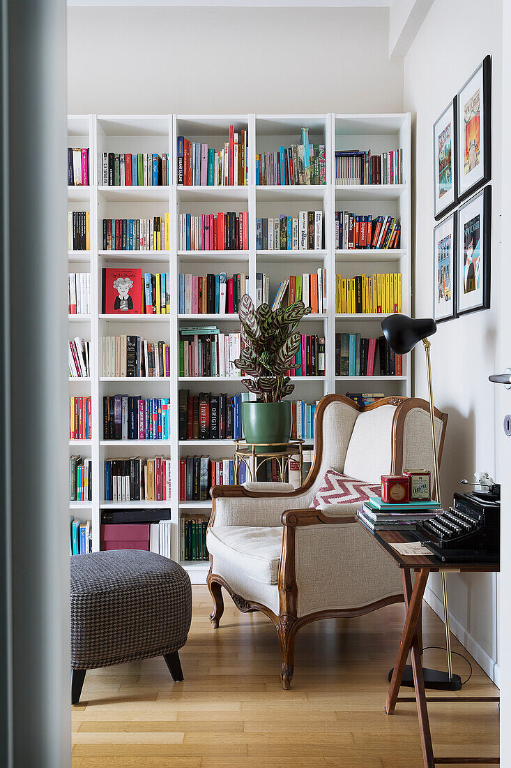 Antiker Ohrensessel vor Bücherwand im Wohnzimmer