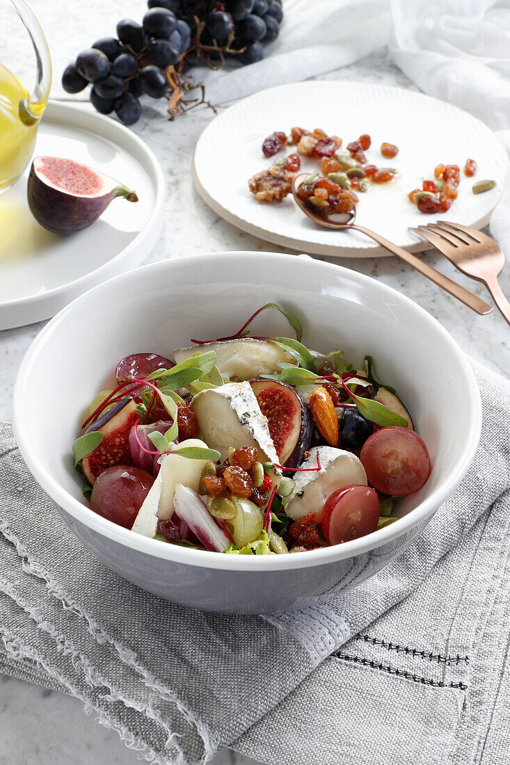 Nuts and raisins salad with goat cheese and grapes