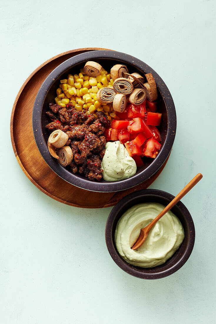 A Mexican burrito bowl with beef mince, corn and tortillas