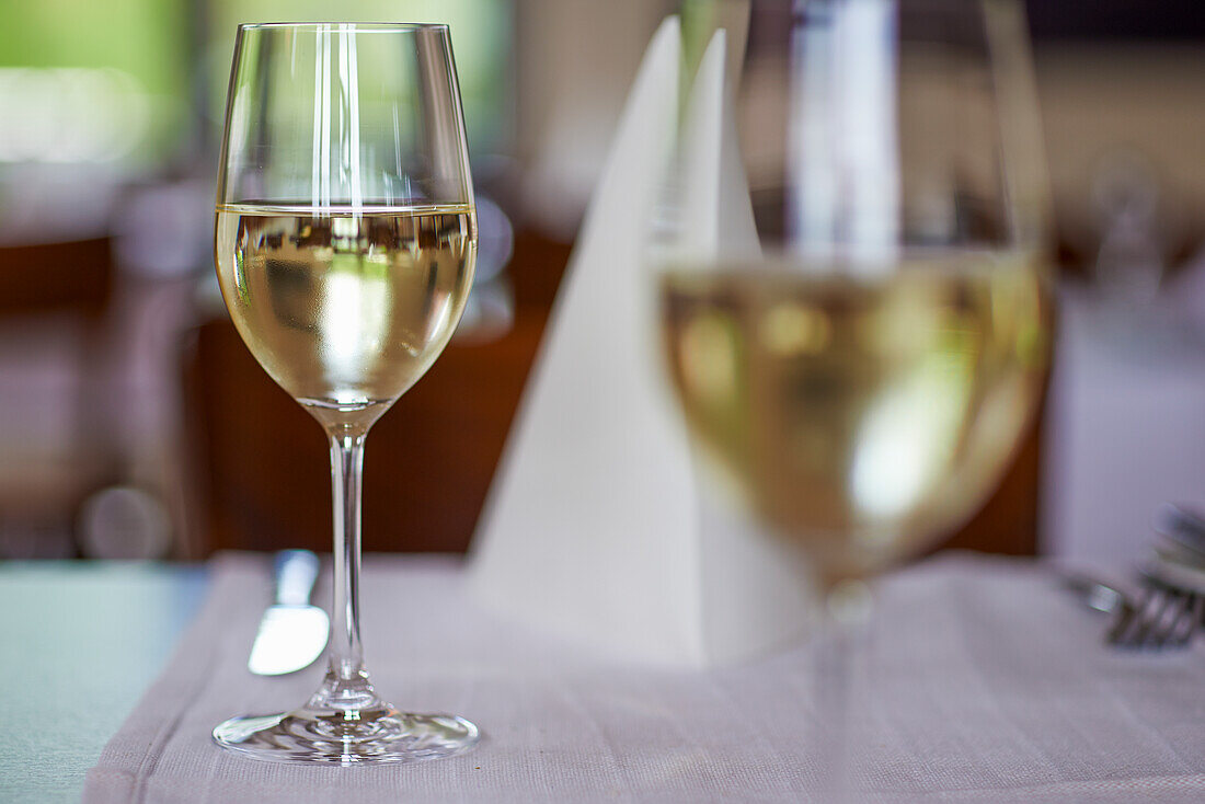 Glas Weißwein auf gedecktem Tisch