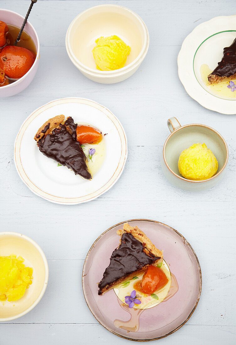 Mandelkuchen mit Schokoladenglasur serviert mit Orangensirup und Eis