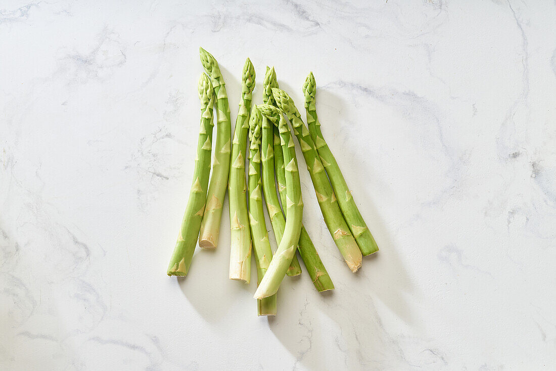 Fresh green asparagus on white marble table