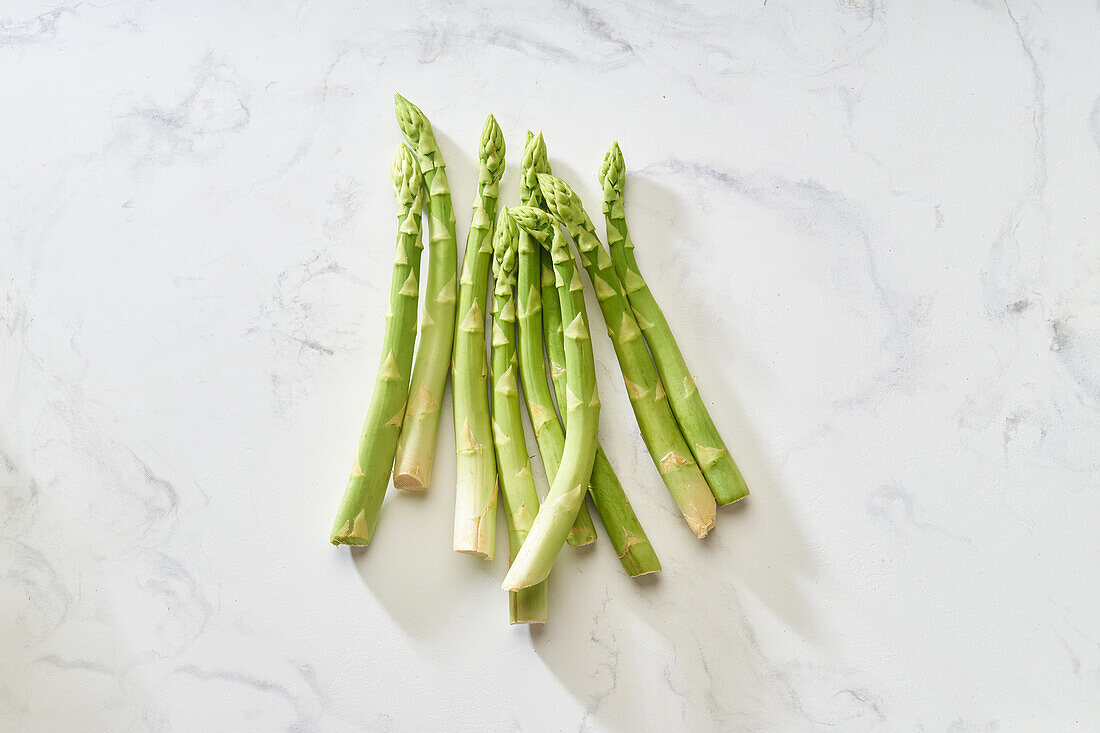 Frischer grüner Spargel auf Marmoruntergrund