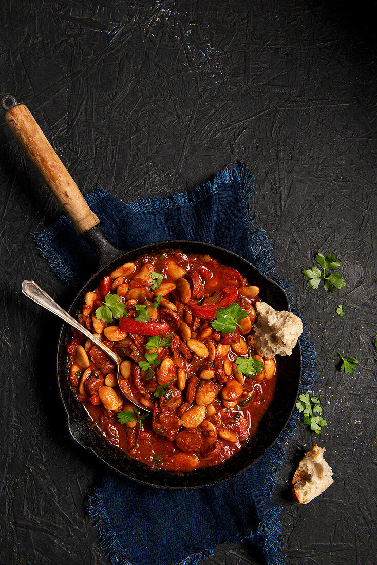 Butter beans in spicy tomato sauce with chilli, smoked paprika, chorizo sausage, parsley