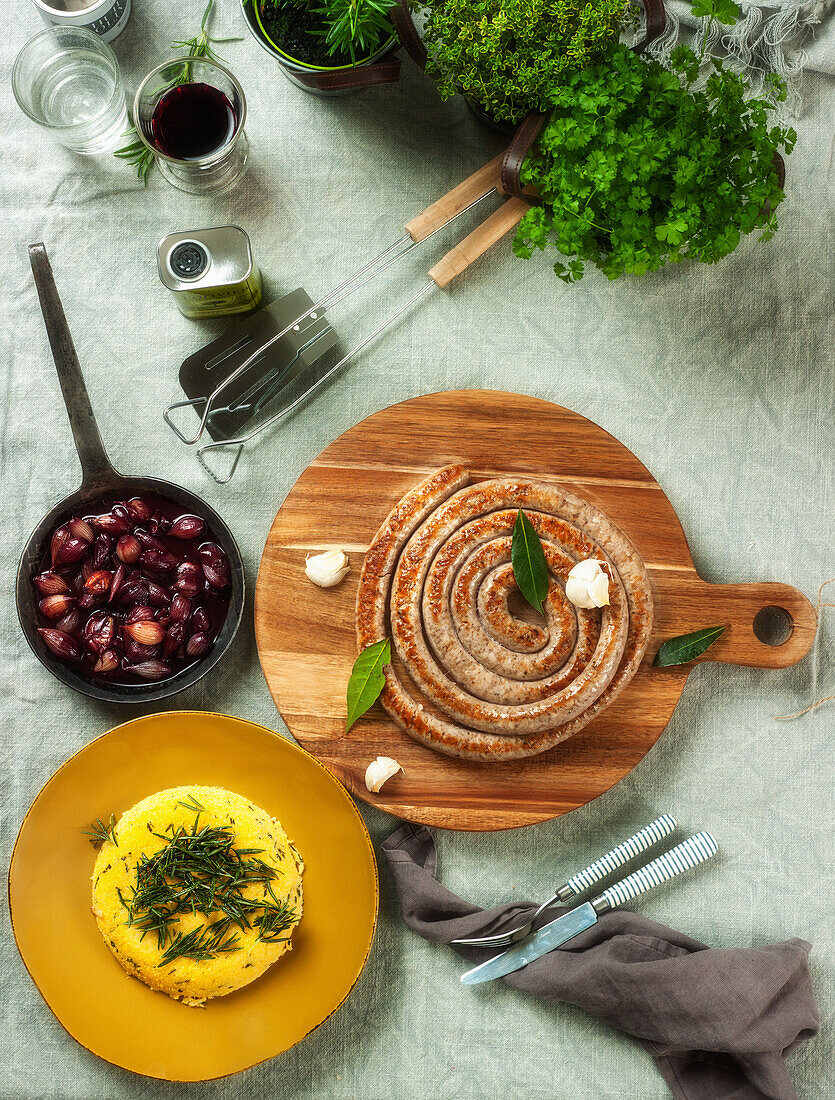 A grilled sausage spiral with polenta and balsamic shallots