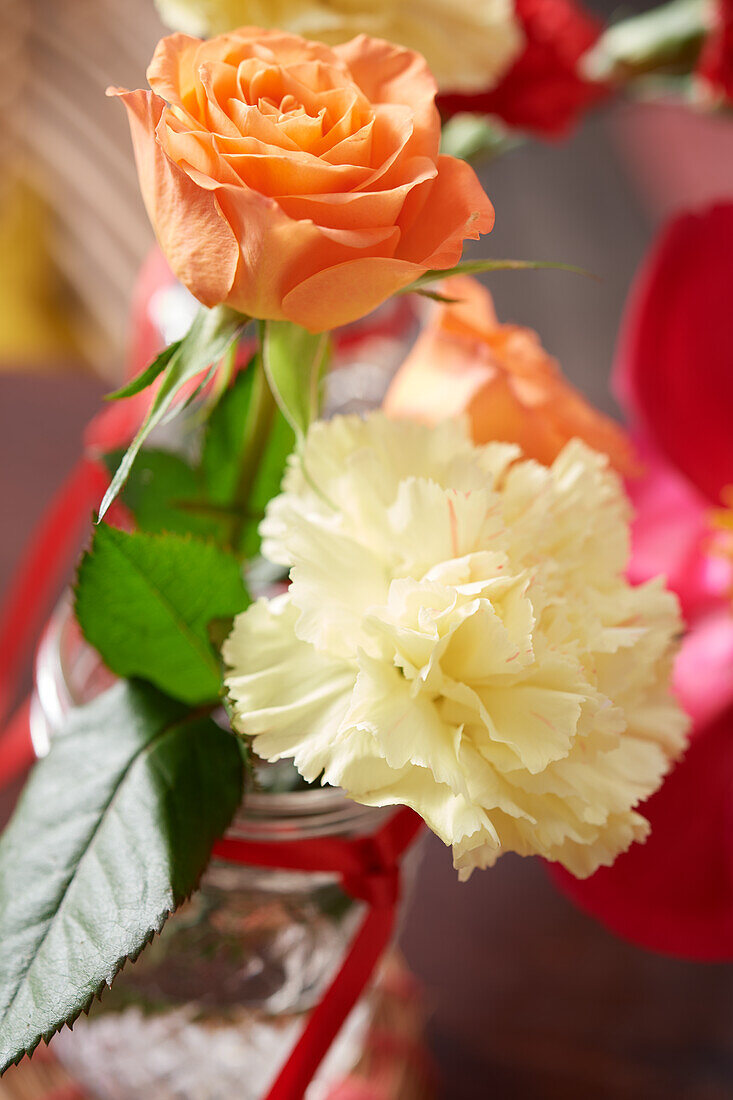 Salmon-colored rose and white carnation as a table decoration