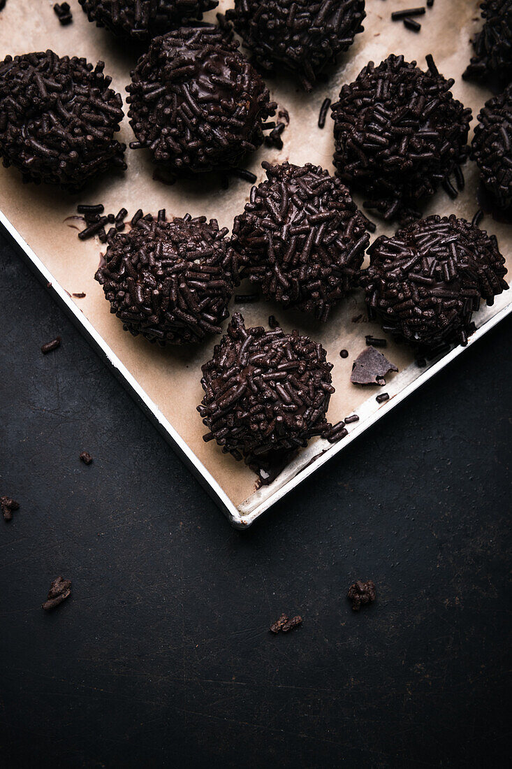 Vegan cake pralines coated with dark chocolate sprinkles