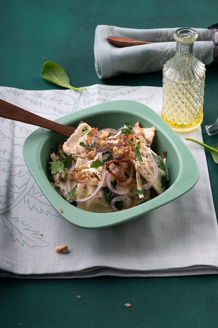 Vegan vegetable ravioli in cashew cream with leaf spinach, onions and shaved almond cheese