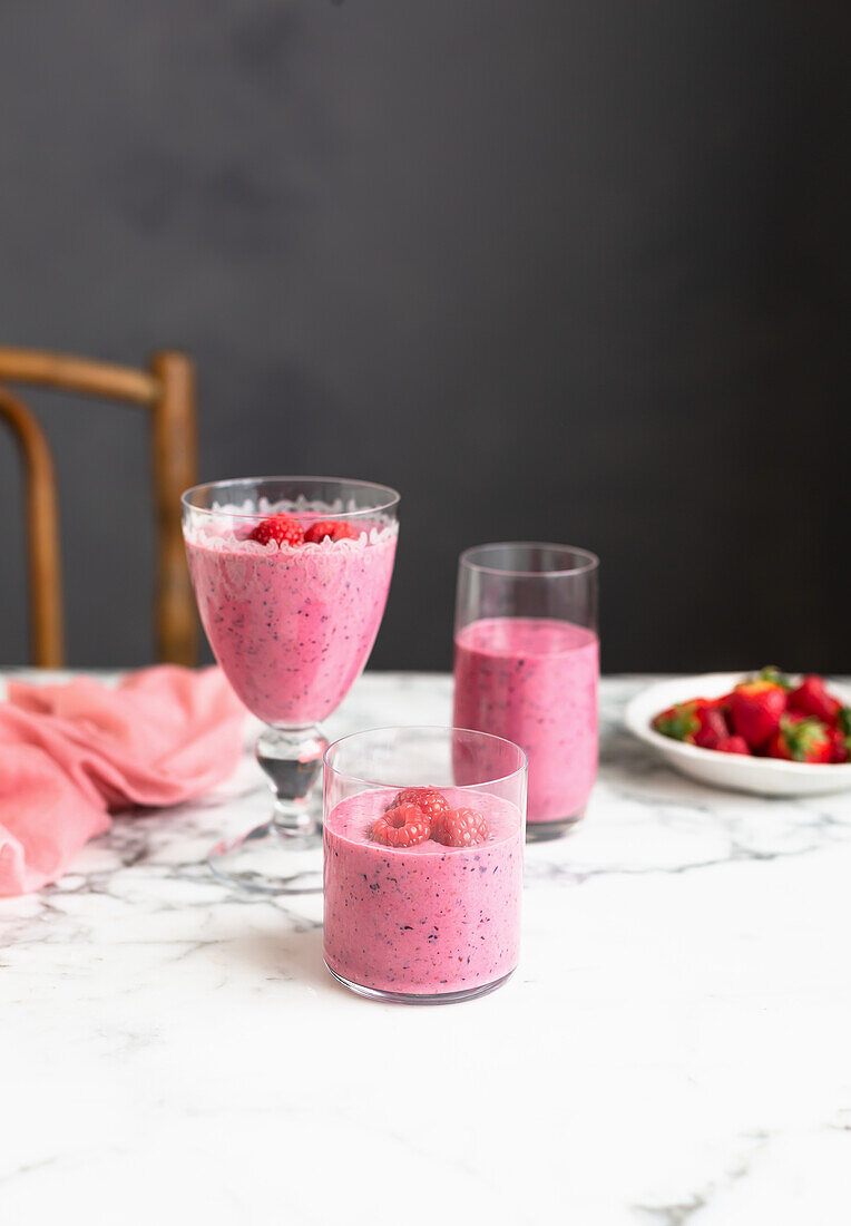 Rote Beeren-Smooties in Gläsern auf Tisch