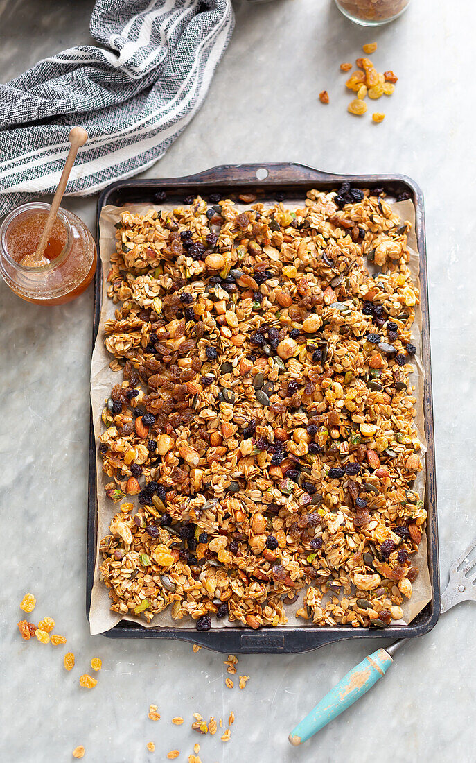 Homemade granola muesli with honey on a baking tray