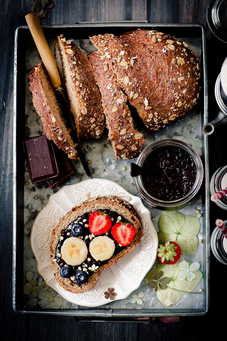 An open sandwich with chocolate spread, banana and strawberry