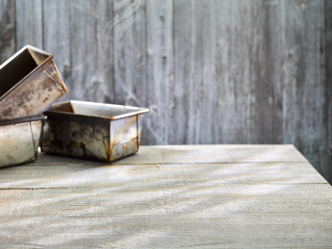 Vintage baking pans in front of a wooden background