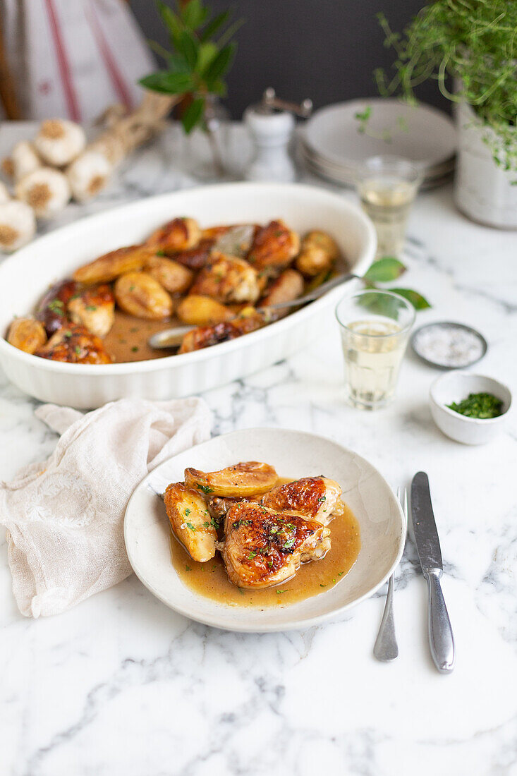 Gebratene Hähnchenteile mit Kartoffeln und Würstchen