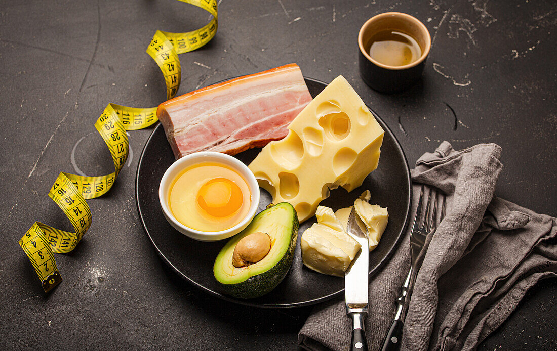 Keto foods as butter, olive oil, fried egg, avocado, fat meat bacon, cheese for ketogenic diet