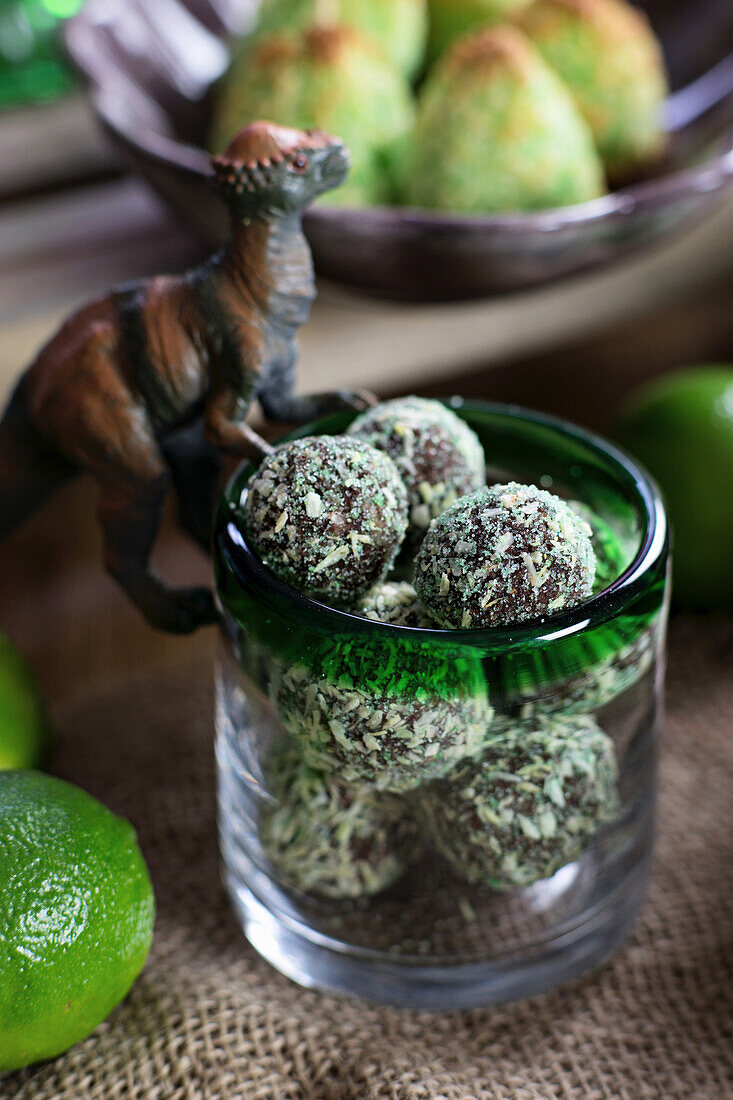 Chocolate-coconut balls in a glass decorated with a dinosaur figure