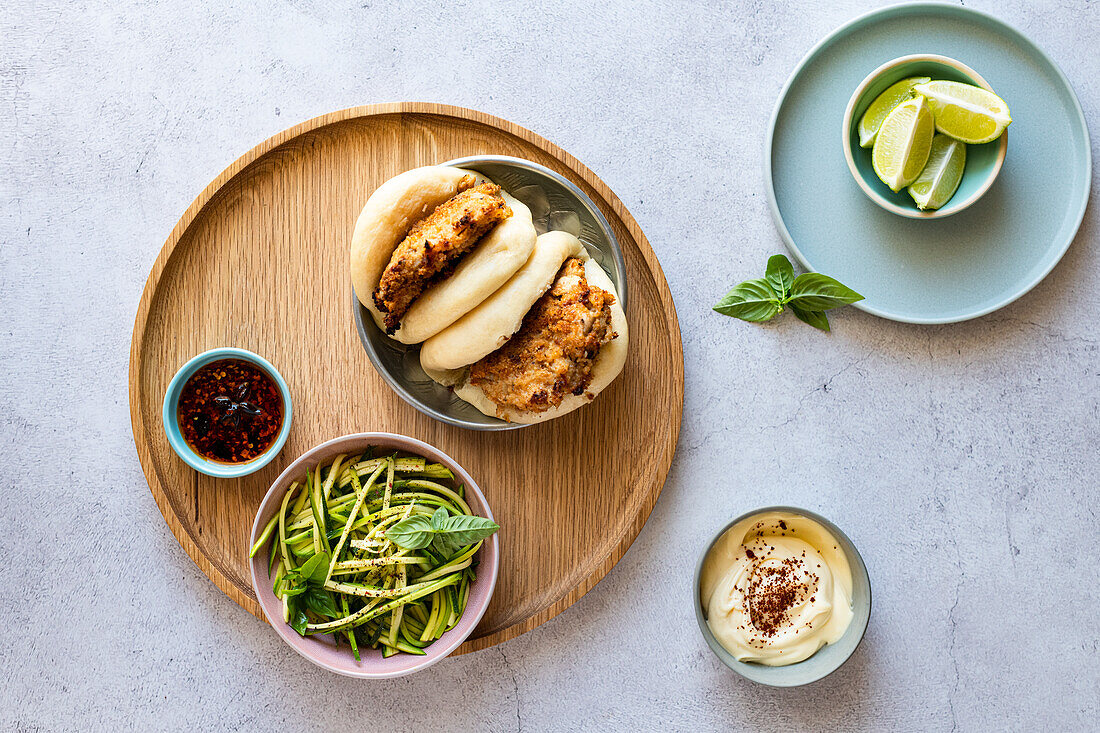 Oven baked buttermilk chicken with sourdough breadcrumbs served in Bao with zucchini noodle salad