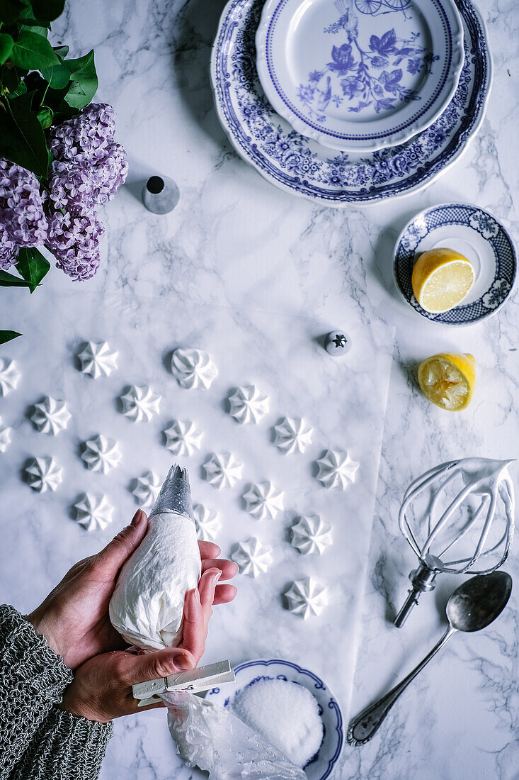 Meringue dots being piped onto marble slab