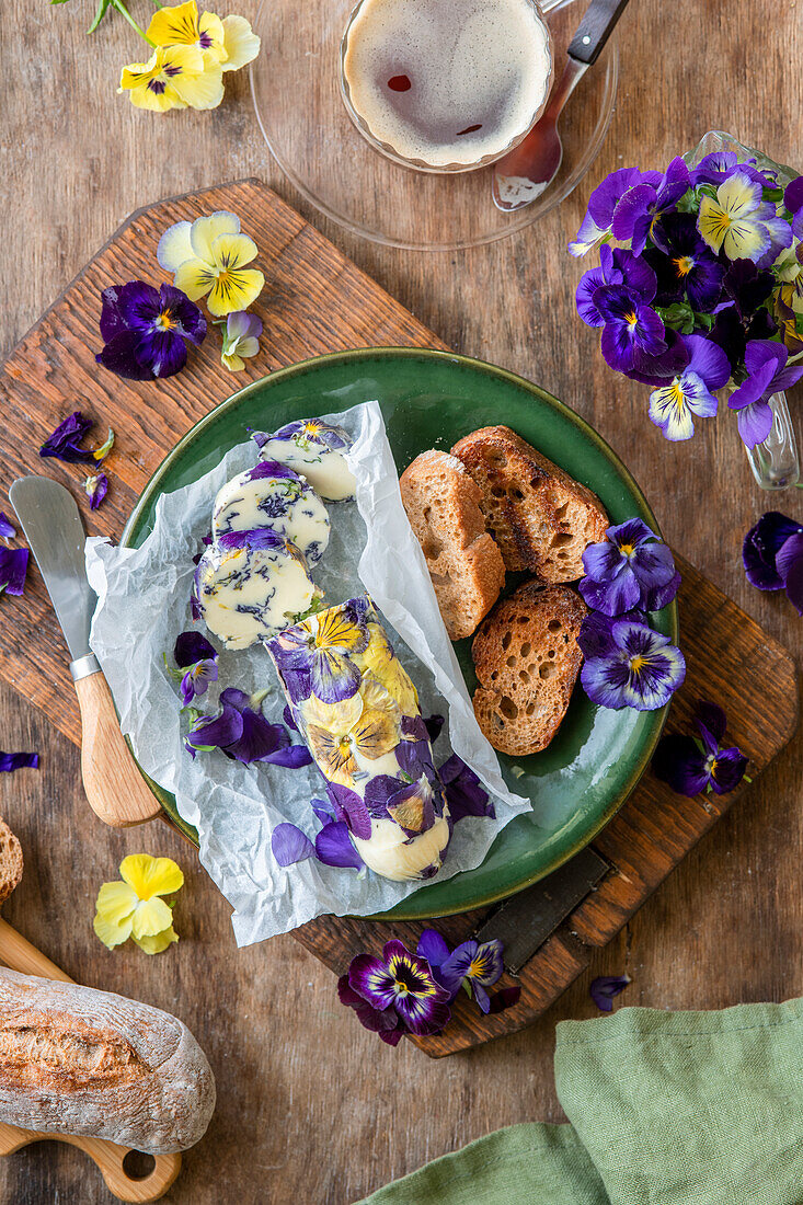 Viola-Butter mit Röstbrot auf grünem Teller