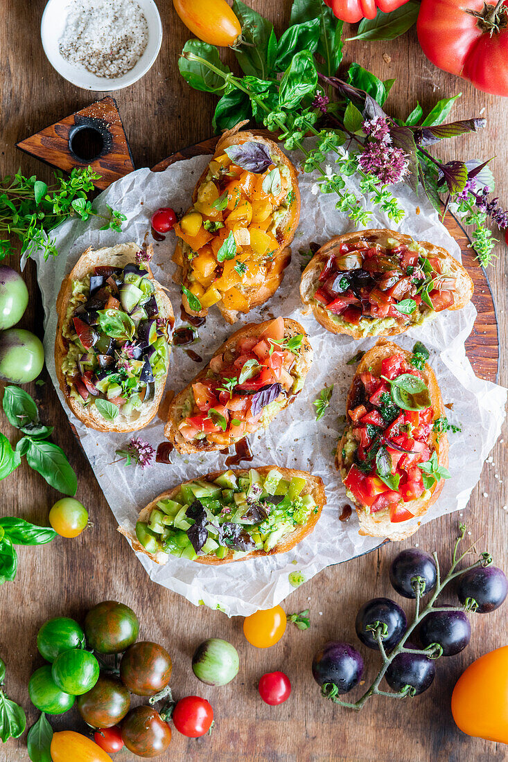 Tomatenbruschettas mit Avocado, Balsamico-Tomaten, Basilikumöl und marinierten Tomaten