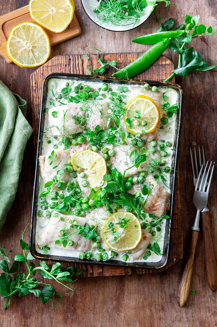 Fish fillet baked with green peas and cream