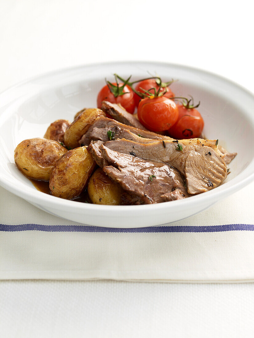 Roast lamb with cherry tomatoes and new potatoes
