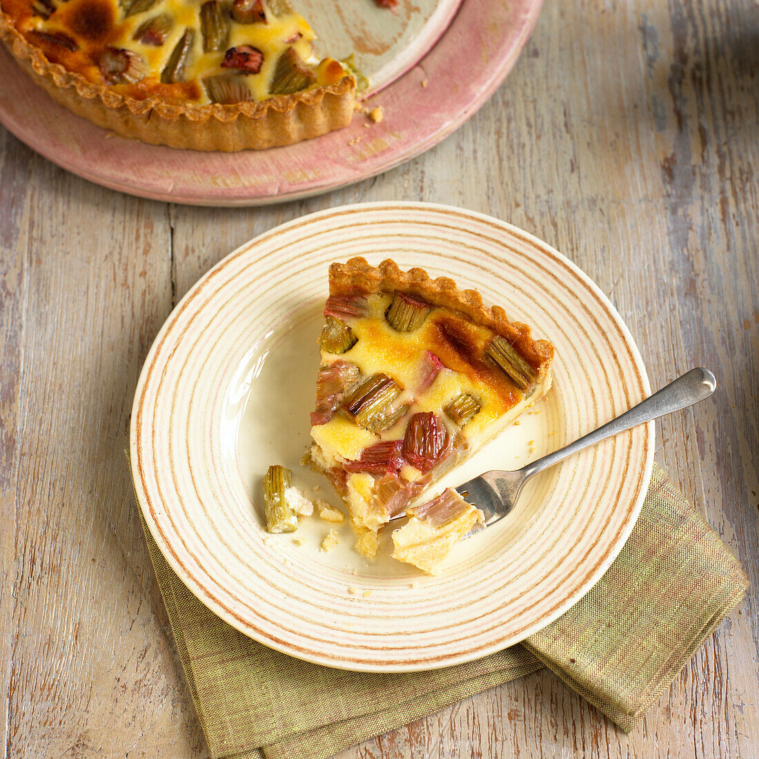 Half-eaten slice of rhubarb and custard tart