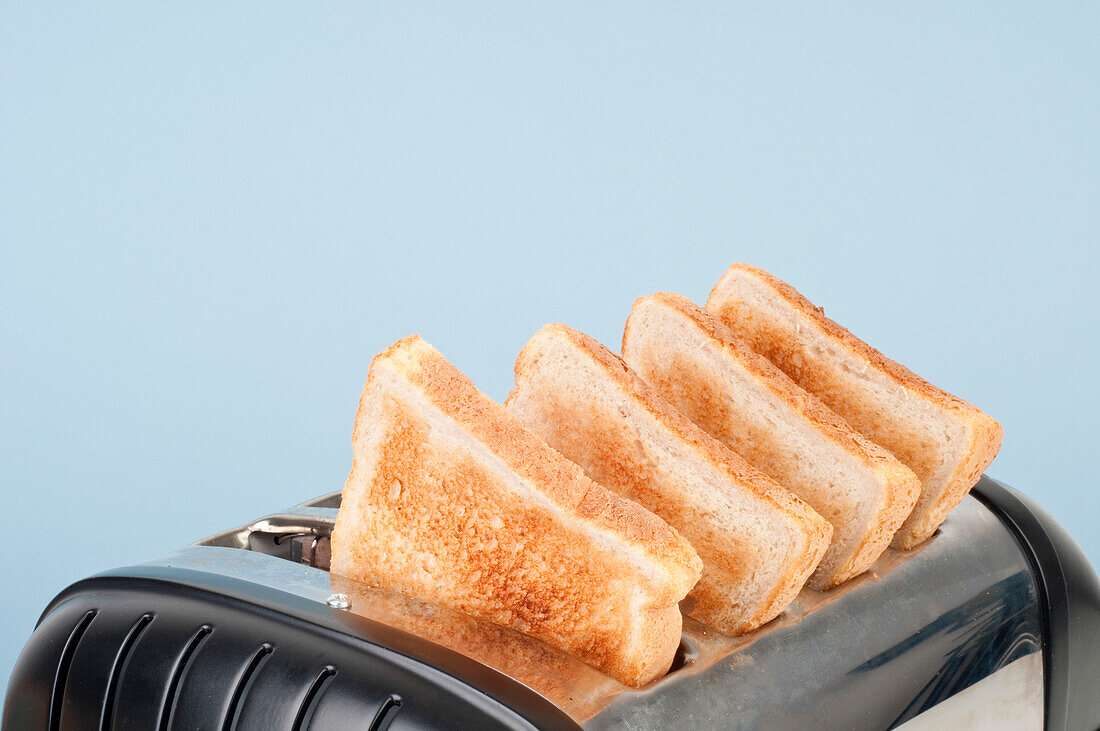Four slices of white toast in four-slot toaster