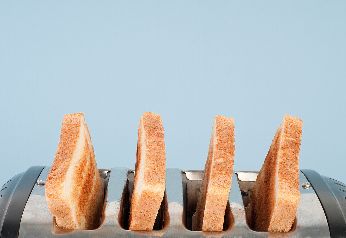 Four slices of toasted white bread in four-slot toaster