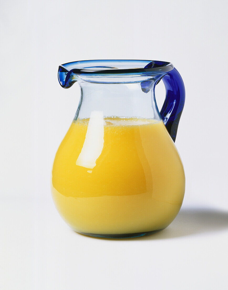 Blue glass jug filled with orange juice