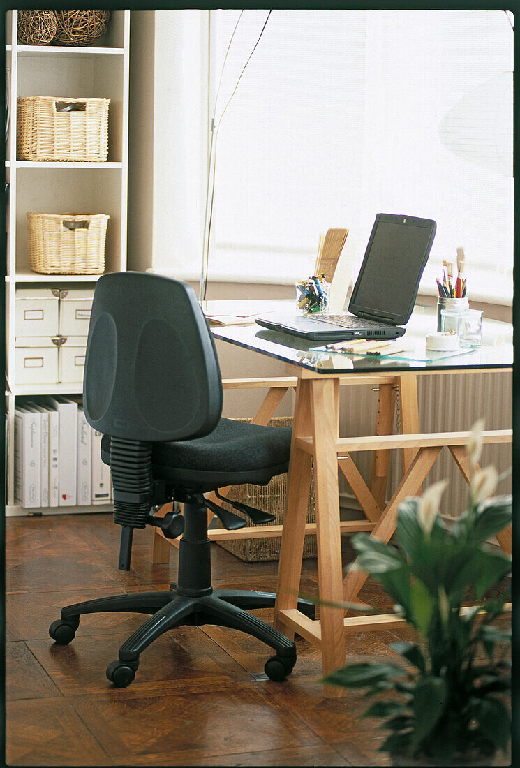 Chair with adjustment levers and desk with lap-top computer