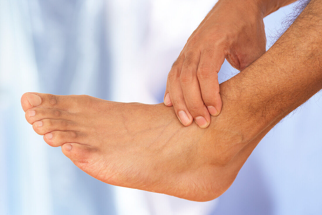 Man massaging ankle using thumb-walking technique