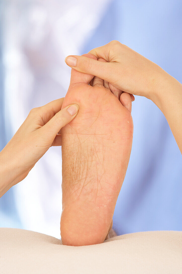 Woman massing foot using thumb-walking technique