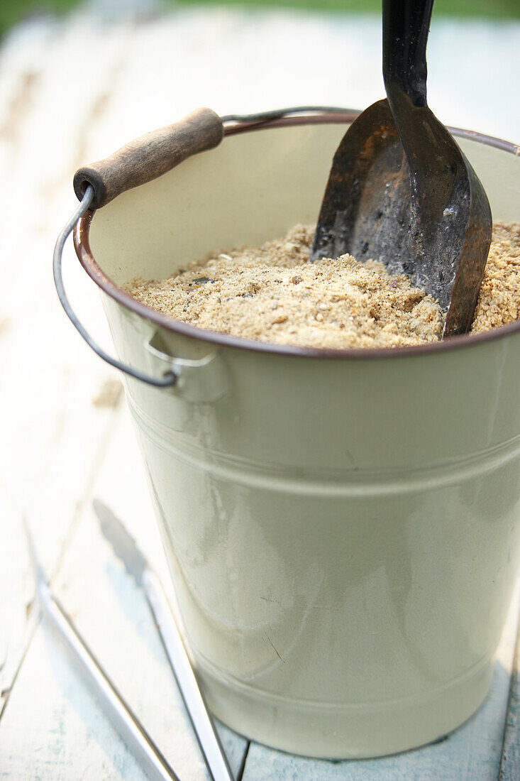 Bucket of sand with small spade and pair of tongs