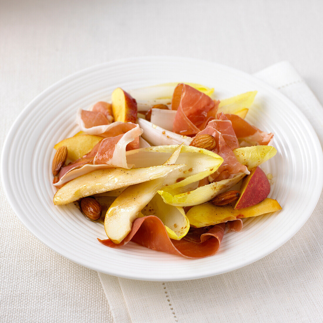 Dish of Parma ham with pear, nectarine and endive