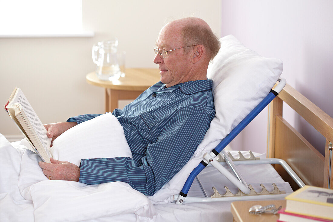 Man sitting up in bed reading