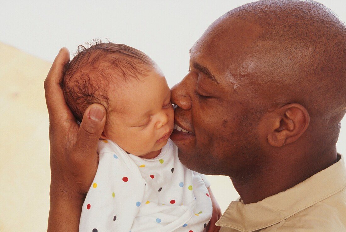Man kissing young baby on the cheek