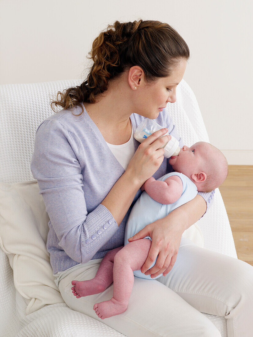 Woman feeding baby from bottle