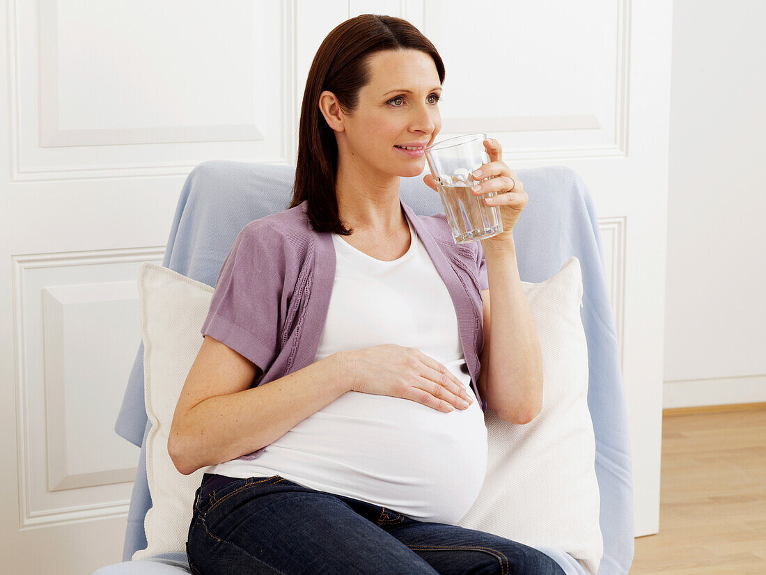 Pregnant woman drinking glass of water