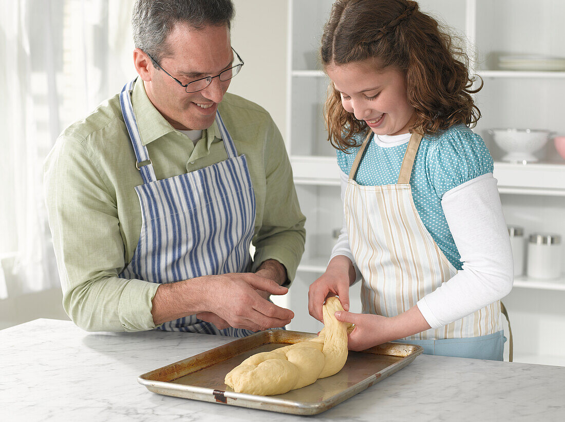 Girl shaping challah dough into plait