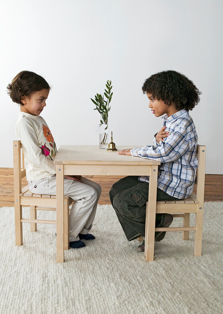Girl and boy sitting opposite each other at peace table
