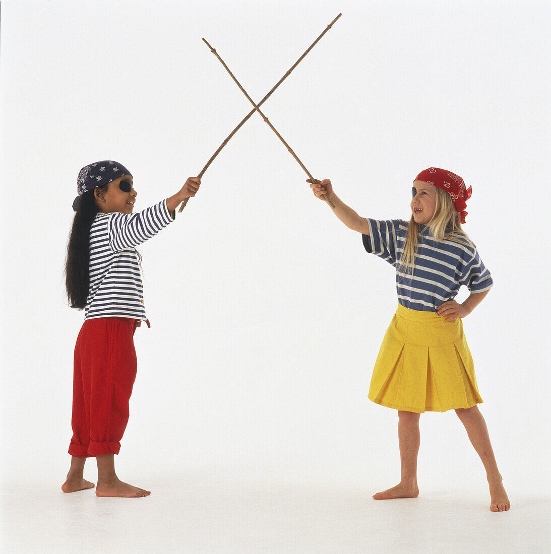 Girls in pirate costumes crossing twig 'swords'