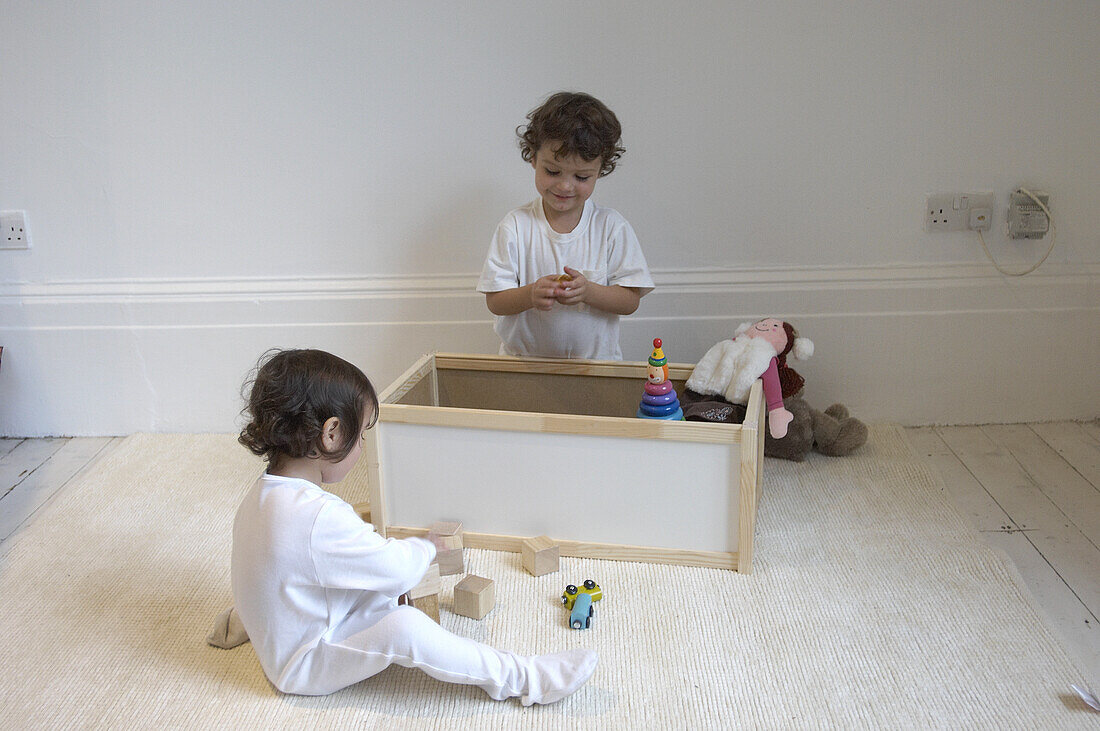 Young boy and young girl playing with box of toys