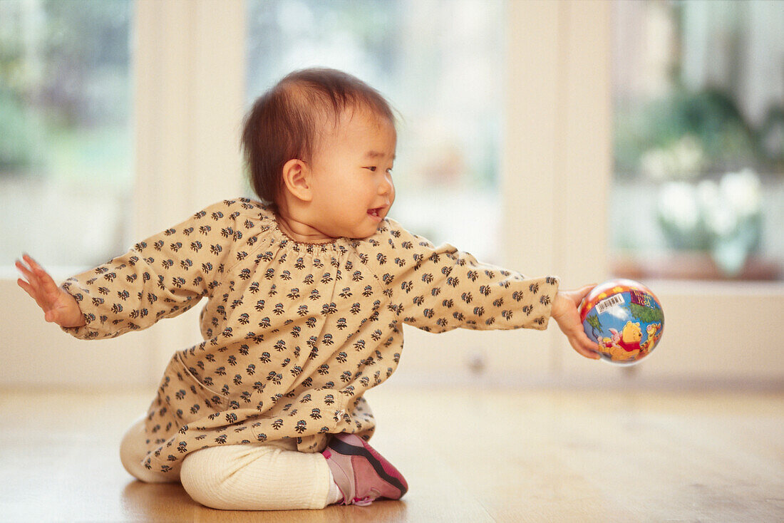 Baby girl holding ball